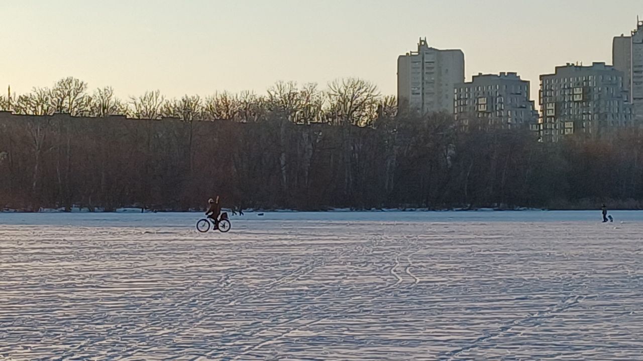 У Дніпрі посеред річки у сутінках гуляють десятки людей з дітьми