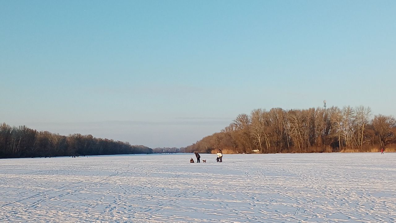 У Дніпрі посеред річки у сутінках гуляють десятки людей з дітьми