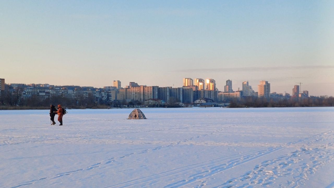 У Дніпрі посеред річки у сутінках гуляють десятки людей з дітьми