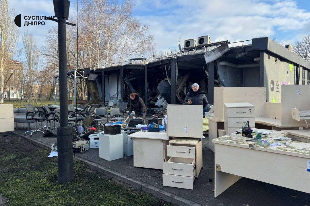 Работники выносят уцелевшее после удара имущество