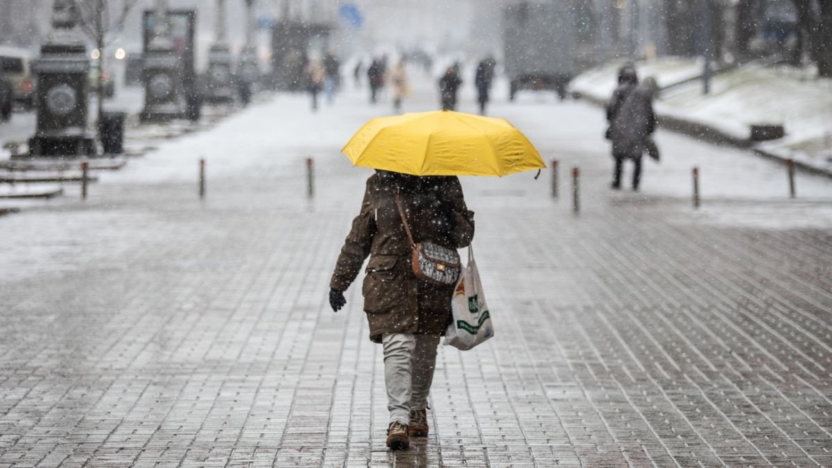 Людина йде під парасолькою