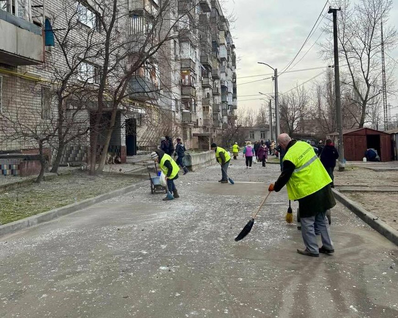 Коммунальщики возле поврежденного обстрелом дома в Днепре