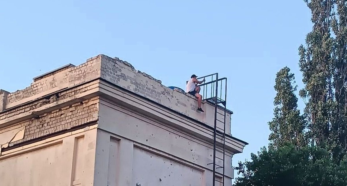 Небезпечні ігри Дитина на даху аварійної будівлі стадіону Локомотив у Дніпрі, небезпечні ігри дітей, закинута будівля з пошкодженим фасадом.