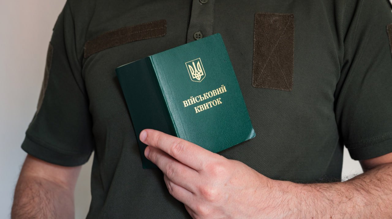 Чоловік тримає в руках військовий квиток