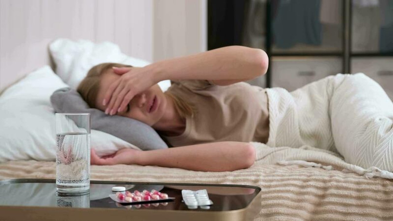 a-sick-woman-throws-an-effervescent-aspirin-tablet-into-a-glass-of-water-while-lying-on-her-bed-video Хвора жінка