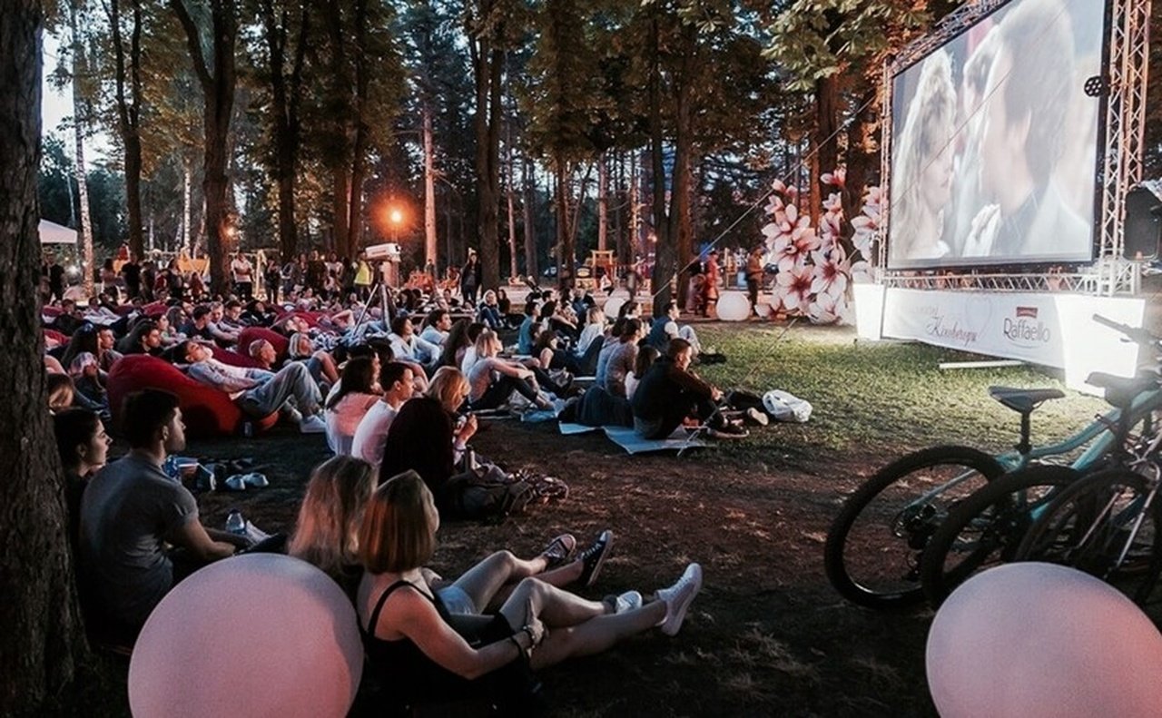 Люди дивляться кіно на природі