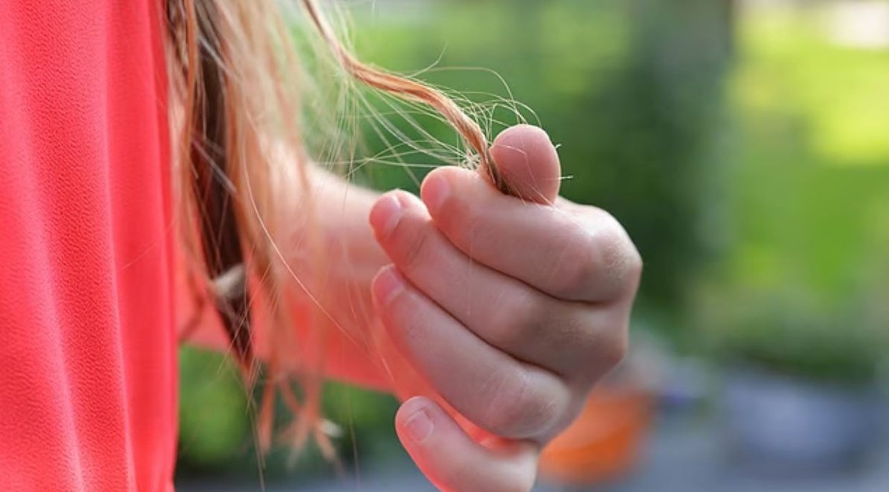 Дитина тримає волосся