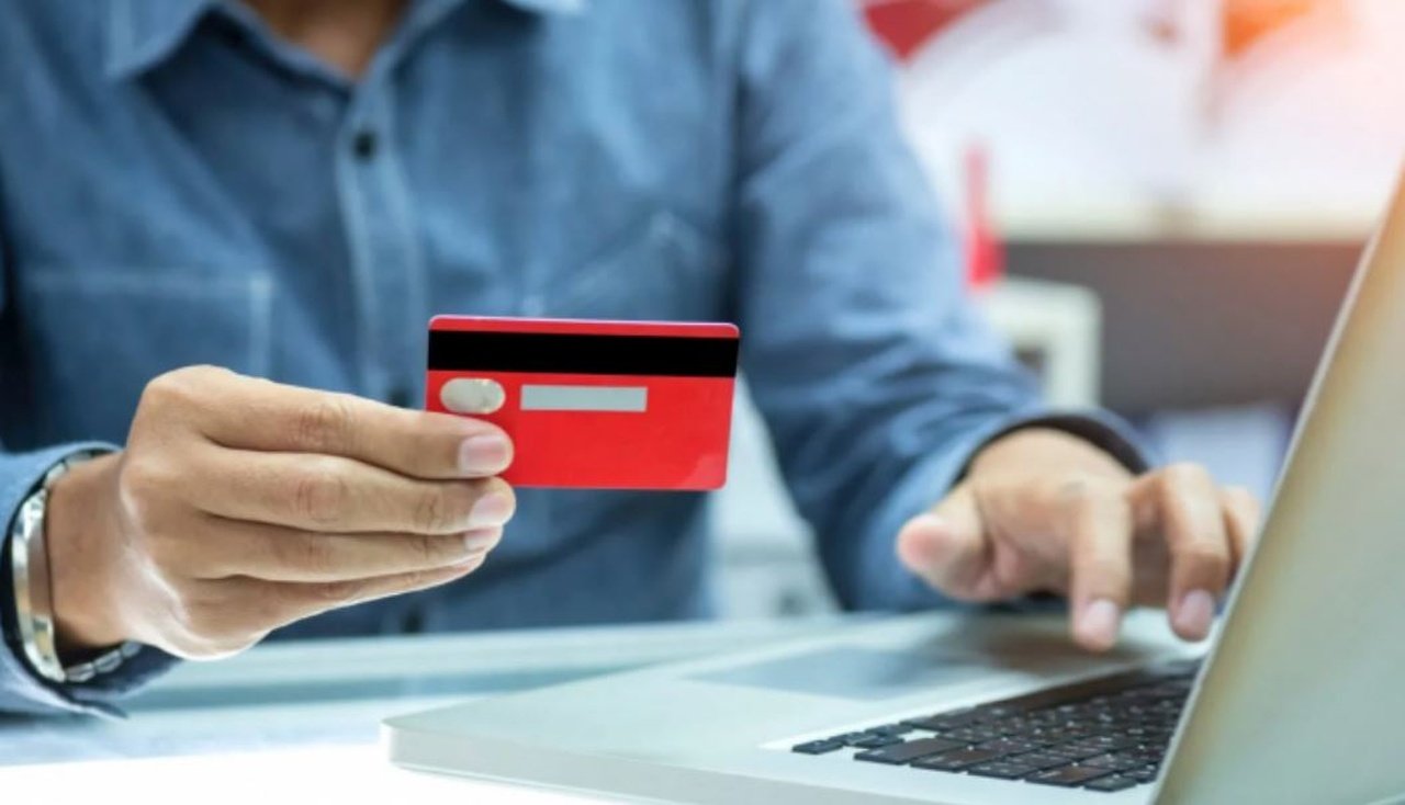 Чоловік тримає в руці банківську картку