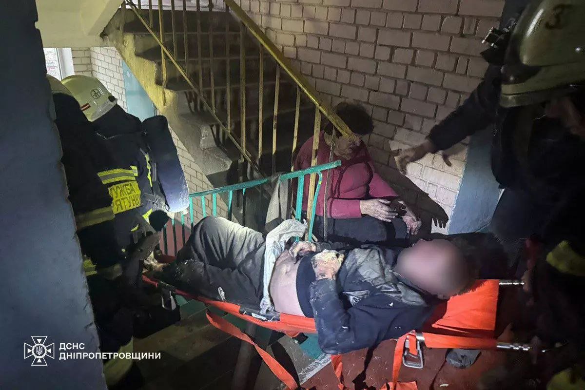 Спасатели выносят мужчину из квартиры в Днепре