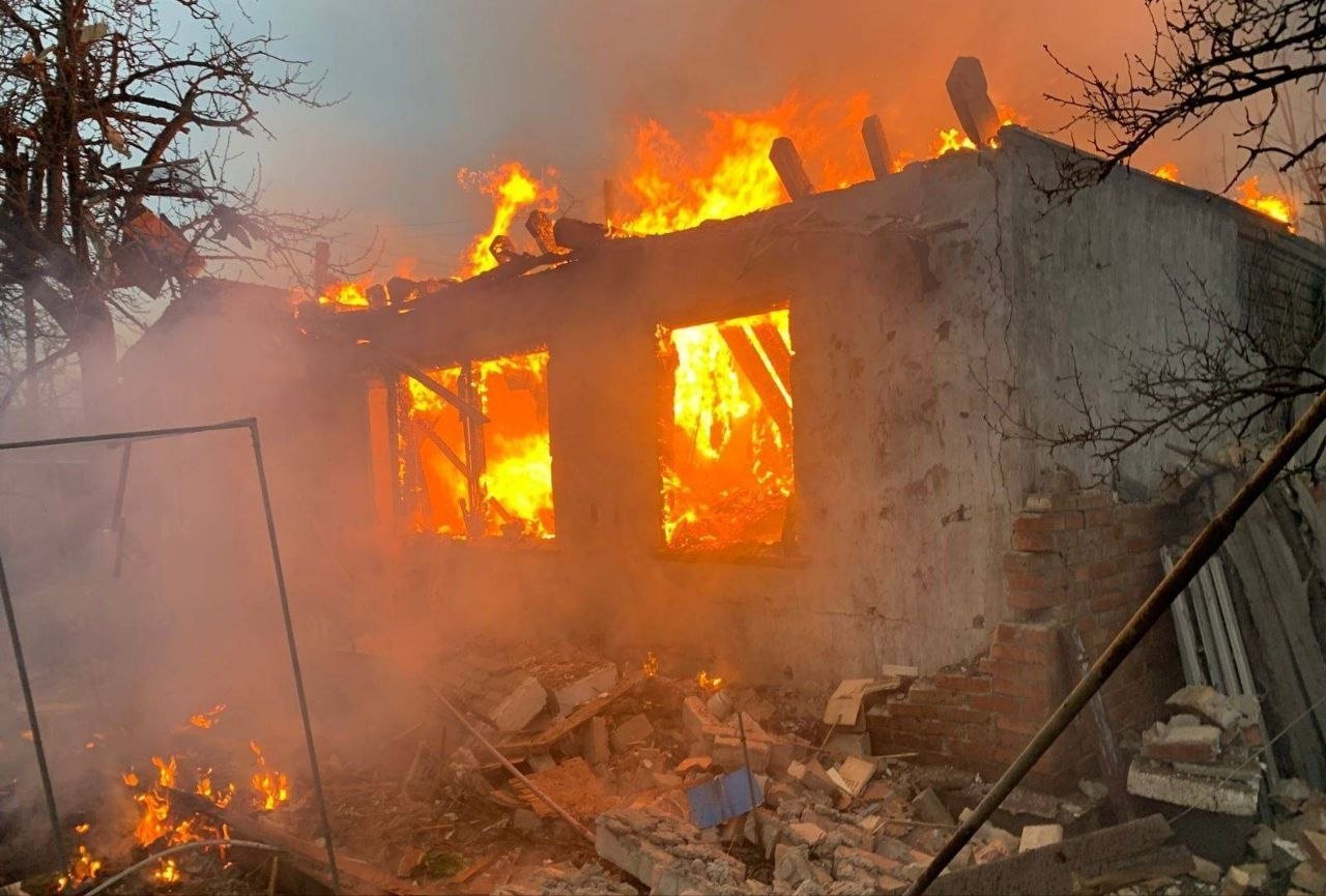 Охваченный огнем дом после атаки