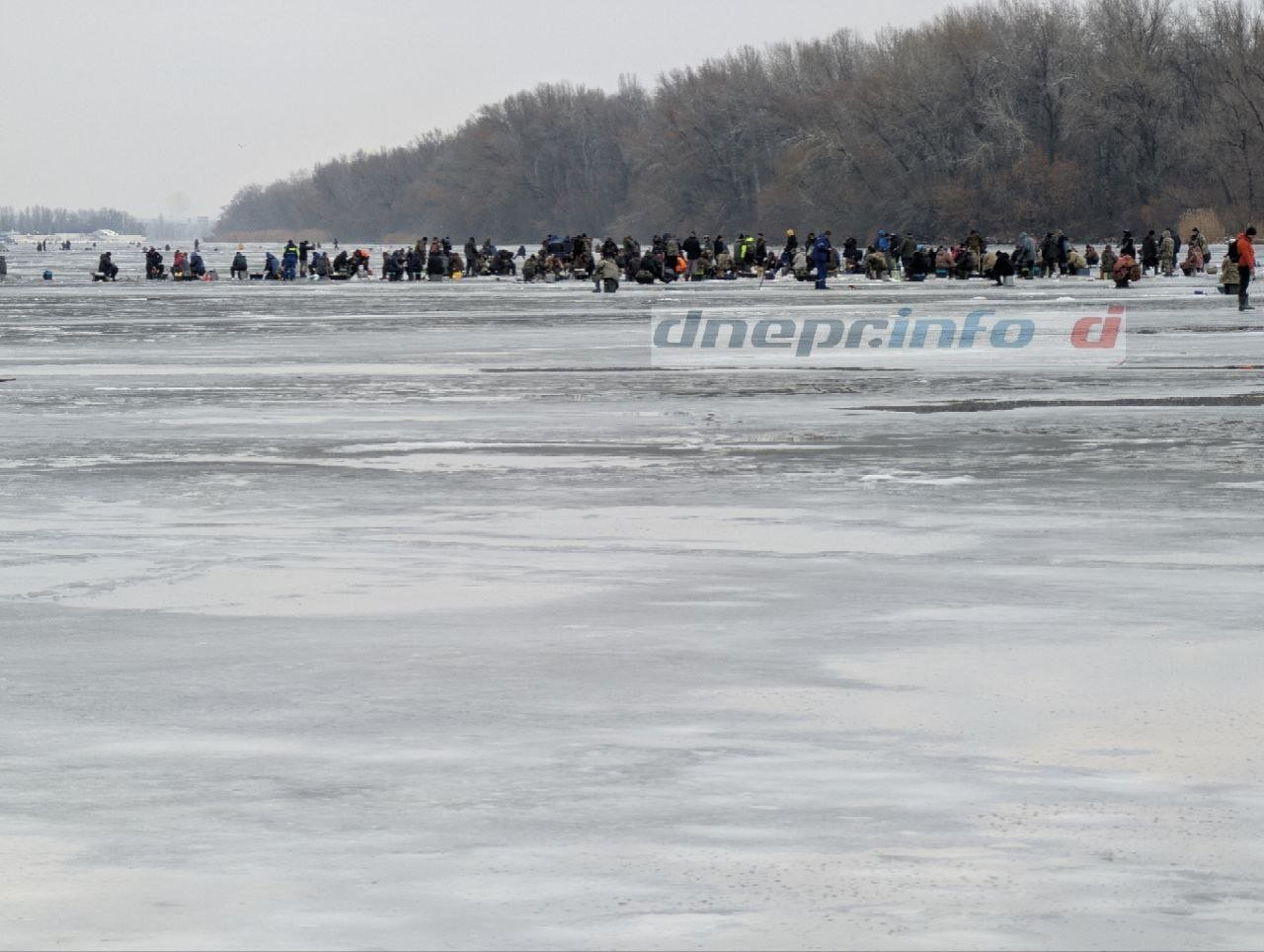 Толпа рыбаков среди замерзшей реки в Днепре