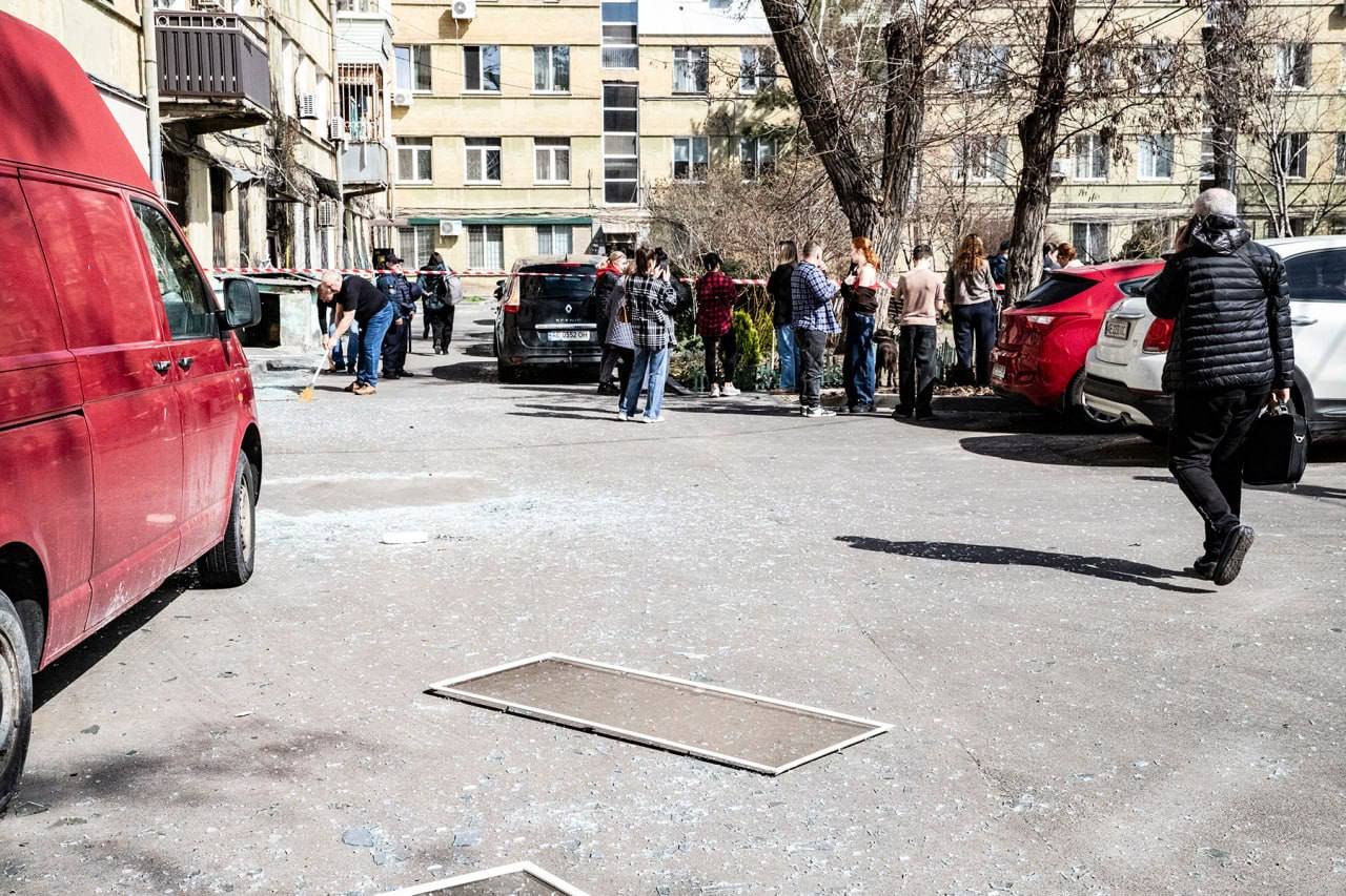 Люди біля понівеченого будинку